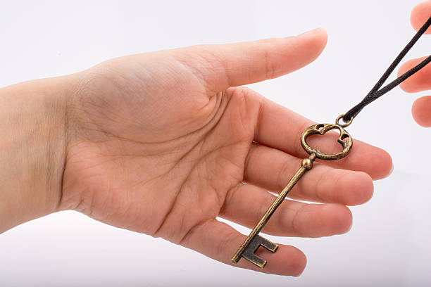 Close-up of a key pendant around a person's neck representing secrets and access 
